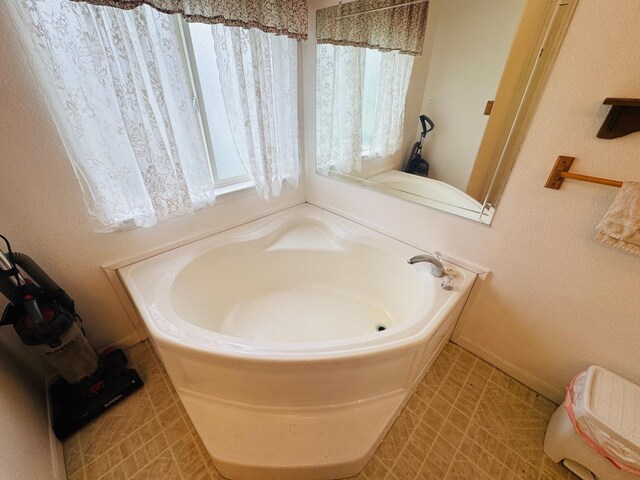 bathroom with tile patterned floors and a tub