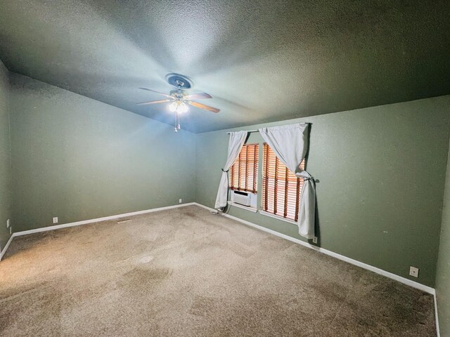 carpeted empty room featuring ceiling fan and a textured ceiling