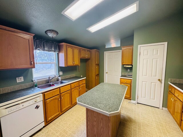 kitchen with dishwasher, sink, a textured ceiling, vaulted ceiling, and a kitchen island