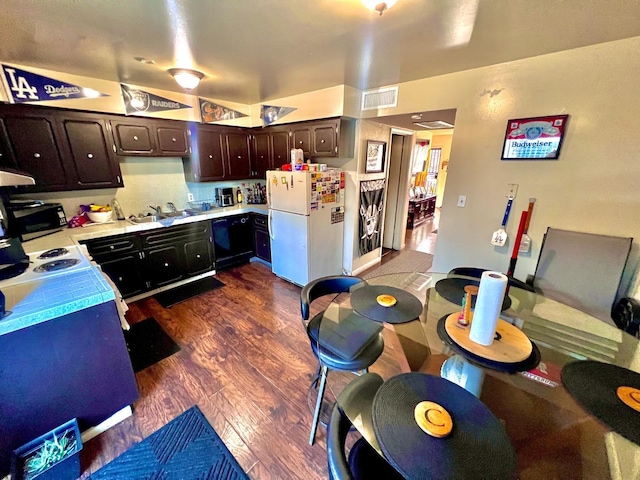 kitchen featuring white fridge, dark hardwood / wood-style flooring, dark brown cabinetry, and sink