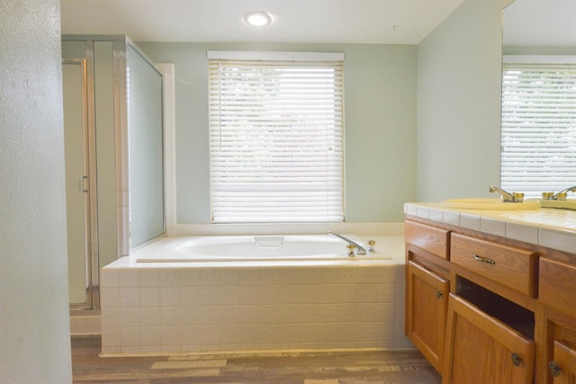 bathroom featuring vanity, wood-type flooring, and shower with separate bathtub