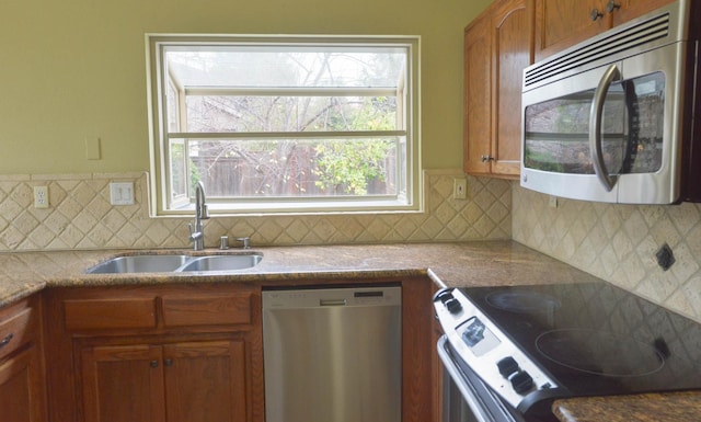 kitchen featuring appliances with stainless steel finishes, backsplash, a wealth of natural light, and sink