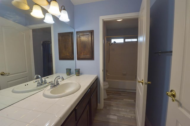 full bathroom with an inviting chandelier, shower / bath combination, toilet, vanity, and hardwood / wood-style flooring