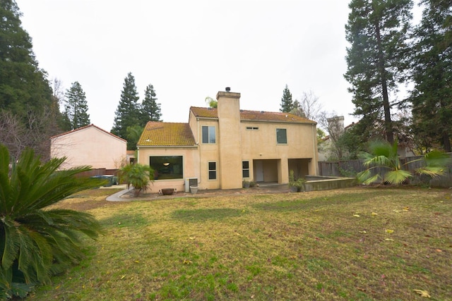 rear view of house featuring a yard