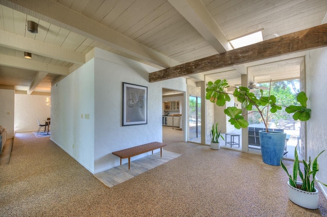 hallway featuring beam ceiling and carpet