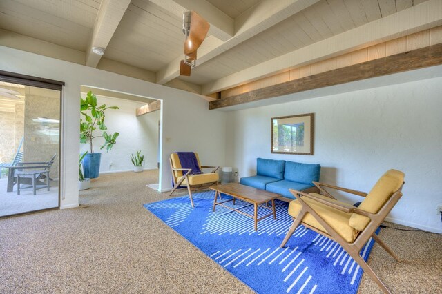 carpeted living room with beamed ceiling