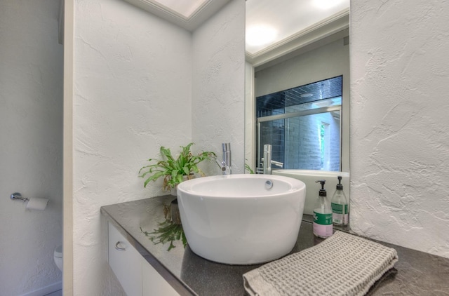 bathroom featuring sink, toilet, and walk in shower