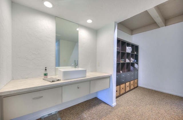 bathroom featuring beam ceiling and vanity