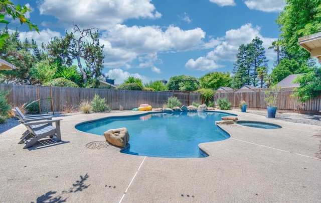 view of swimming pool featuring an in ground hot tub and a patio area