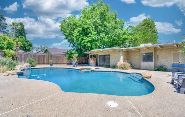 view of pool with a patio area and an in ground hot tub