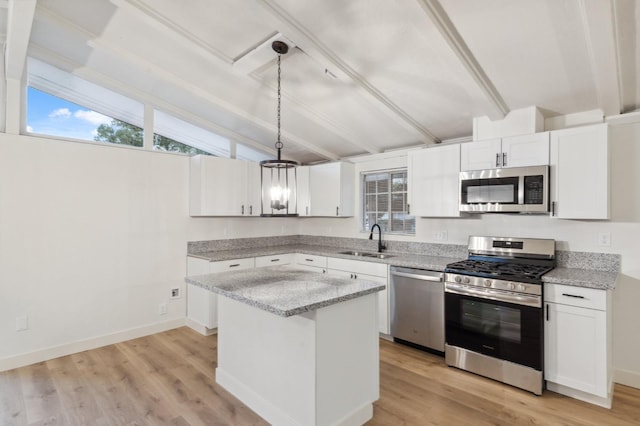 kitchen featuring a kitchen island, white cabinetry, sink, hanging light fixtures, and stainless steel appliances