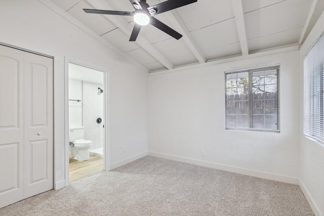 unfurnished bedroom featuring ceiling fan, light colored carpet, connected bathroom, and lofted ceiling with beams