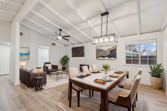 dining area featuring vaulted ceiling with beams and light hardwood / wood-style floors