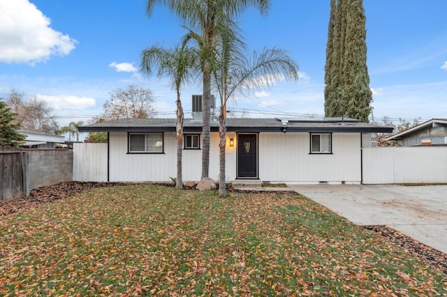 single story home with a front yard and solar panels