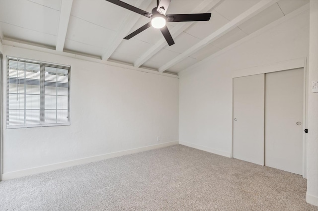 unfurnished bedroom with lofted ceiling with beams, carpet, ceiling fan, and a closet