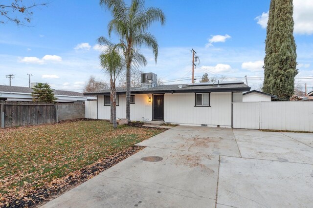 ranch-style home featuring cooling unit and a front yard