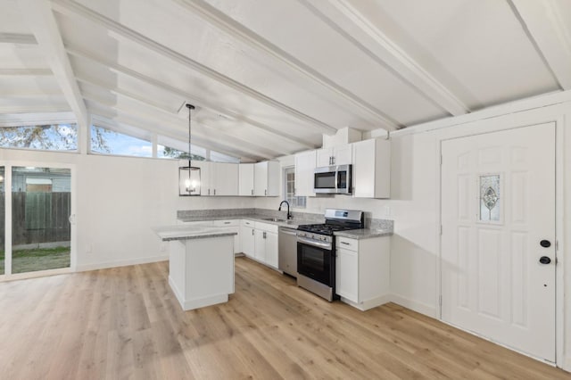 kitchen with sink, white cabinetry, hanging light fixtures, light wood-type flooring, and appliances with stainless steel finishes