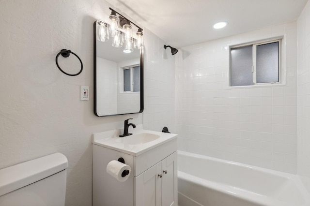 full bathroom with vanity, tiled shower / bath, and toilet