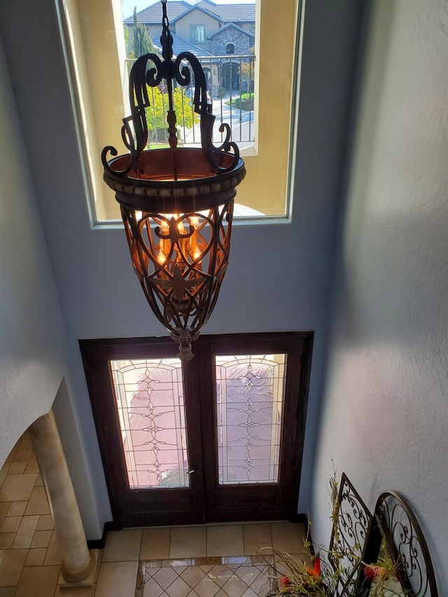 foyer entrance featuring light tile patterned floors, french doors, and a wealth of natural light