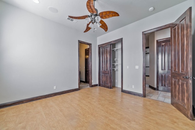 unfurnished bedroom with ceiling fan and light wood-type flooring