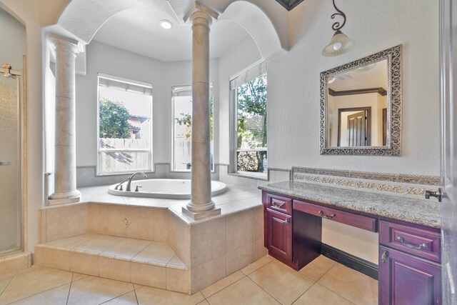 bathroom with tile patterned floors, decorative columns, vanity, and a healthy amount of sunlight