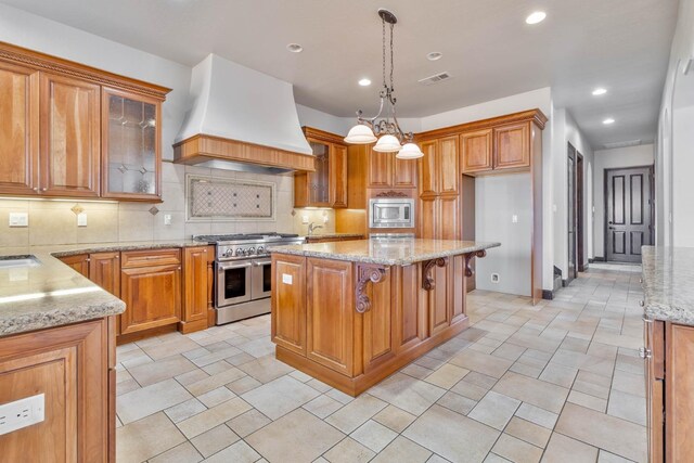 kitchen with premium range hood, decorative light fixtures, decorative backsplash, a kitchen island, and appliances with stainless steel finishes