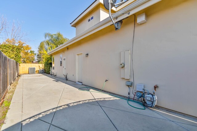 view of side of home with central air condition unit and a patio