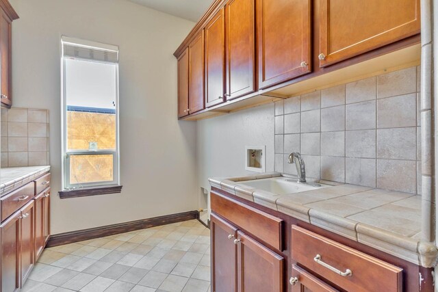 kitchen with tasteful backsplash, tile counters, and sink