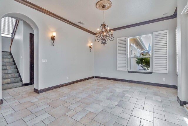 spare room with ornamental molding and a notable chandelier