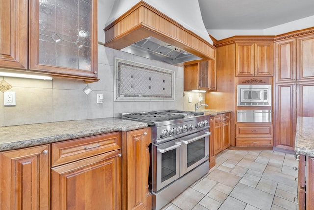 kitchen featuring backsplash, stainless steel appliances, lofted ceiling, and custom exhaust hood