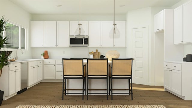 kitchen featuring pendant lighting, a breakfast bar, sink, stainless steel appliances, and white cabinets