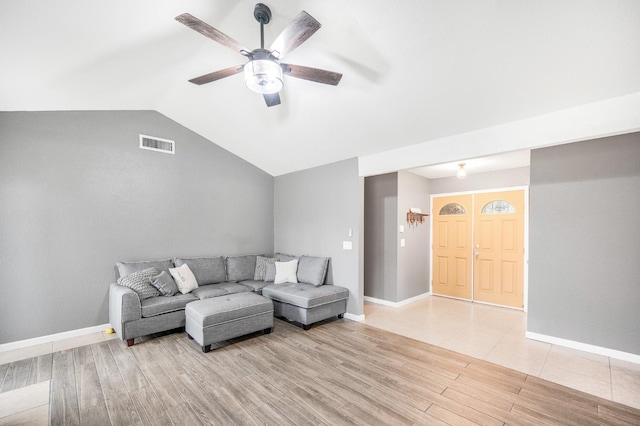 living room featuring ceiling fan, light wood-type flooring, and vaulted ceiling