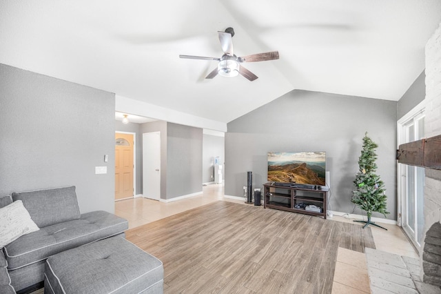 living room with ceiling fan, vaulted ceiling, and light hardwood / wood-style flooring