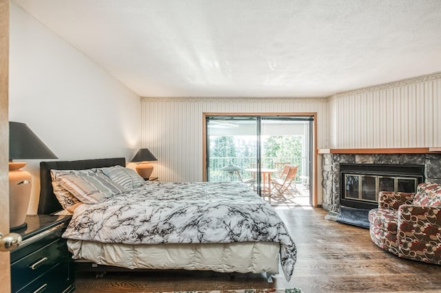 bedroom featuring access to outside, a fireplace, and hardwood / wood-style floors