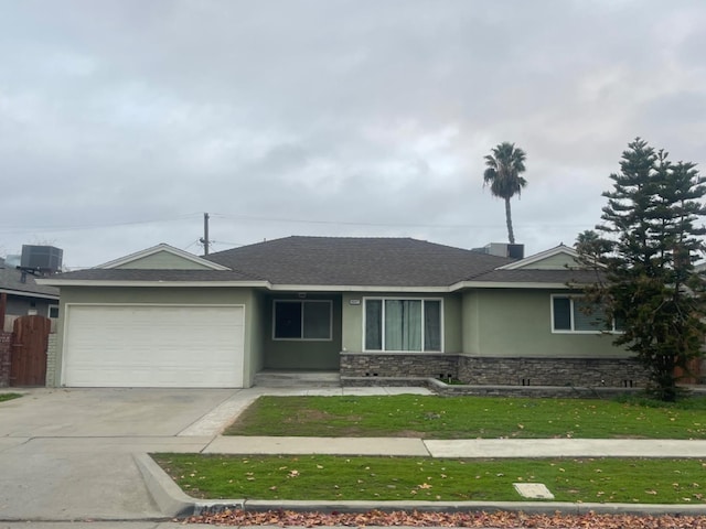 ranch-style home with cooling unit, a garage, and a front lawn