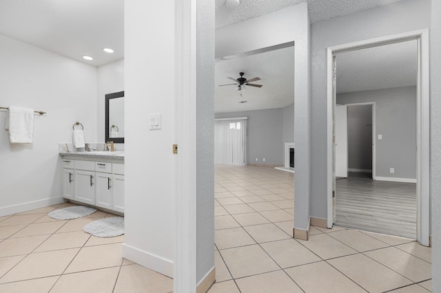 bathroom featuring tile patterned flooring, vanity, a textured ceiling, and ceiling fan