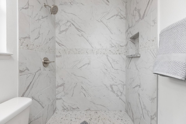 bathroom with toilet and tiled shower