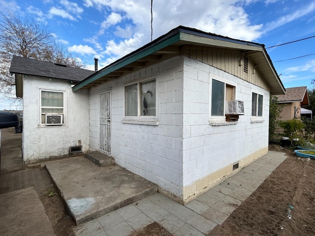 view of property exterior with cooling unit and a patio