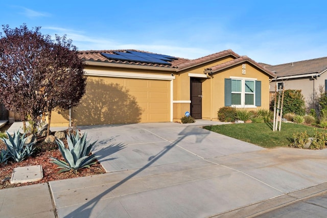 single story home featuring a garage and solar panels