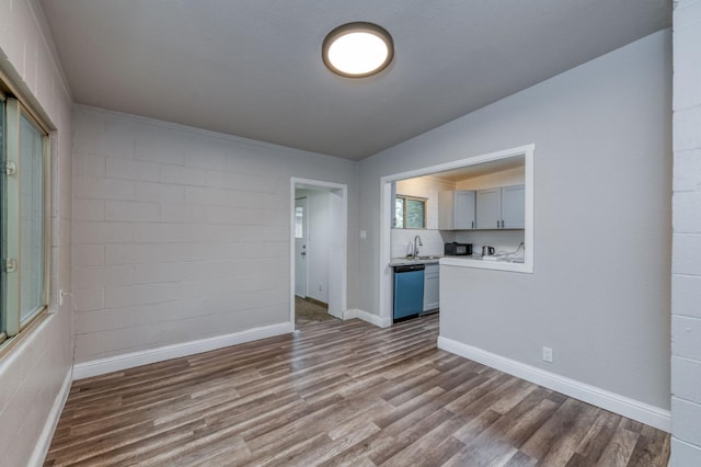 interior space featuring sink, wood-type flooring, and vaulted ceiling