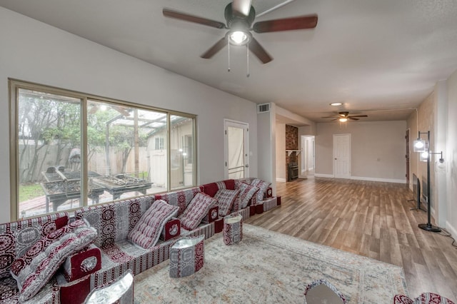 living room featuring ceiling fan and light hardwood / wood-style flooring