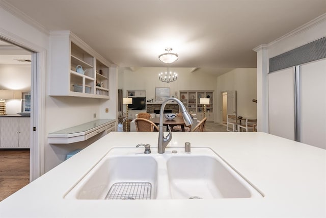 kitchen with sink, hanging light fixtures, dark hardwood / wood-style flooring, a chandelier, and white cabinets