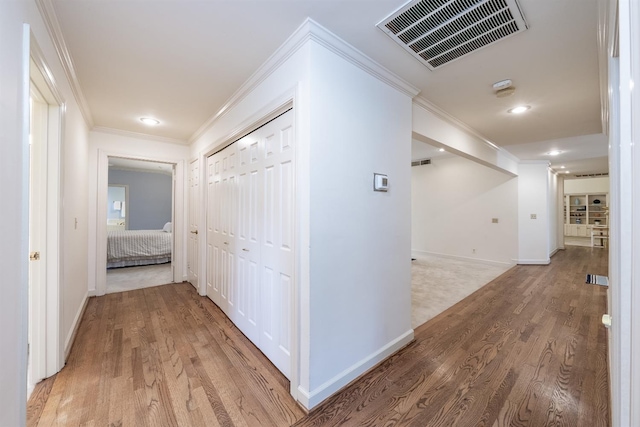 corridor featuring ornamental molding and hardwood / wood-style flooring