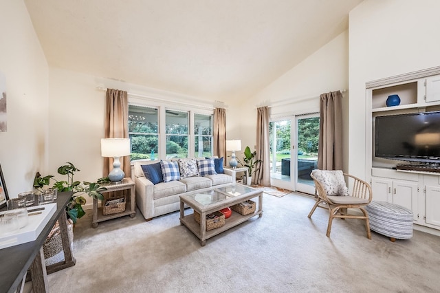 living room with light carpet and high vaulted ceiling