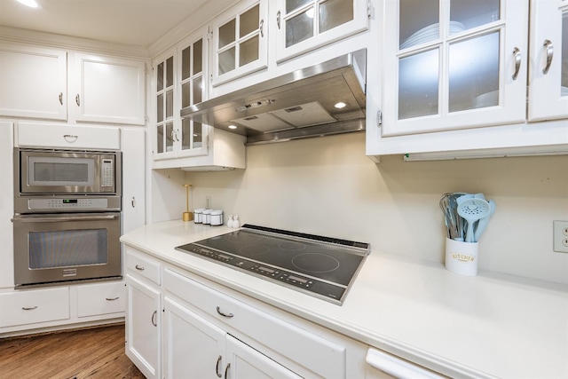 kitchen with white cabinets, hardwood / wood-style floors, and appliances with stainless steel finishes