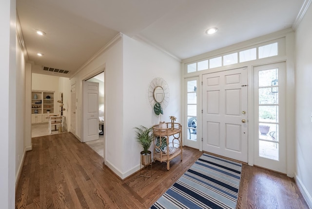 entrance foyer featuring crown molding and dark wood-type flooring