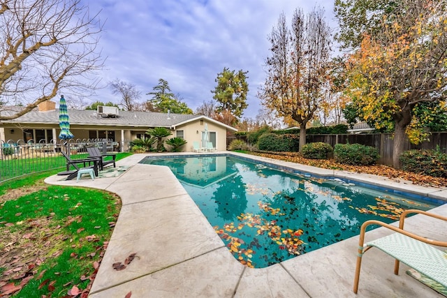 view of pool featuring a lawn and a patio