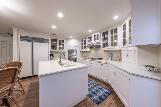 kitchen featuring a center island with sink, sink, built in appliances, dark hardwood / wood-style flooring, and white cabinetry