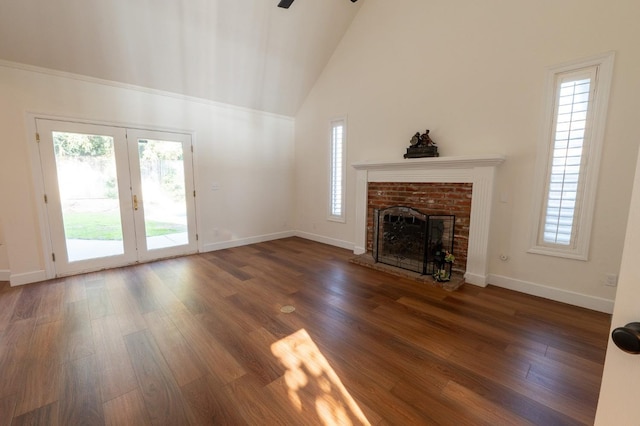 unfurnished living room with ceiling fan, high vaulted ceiling, dark hardwood / wood-style floors, and a brick fireplace