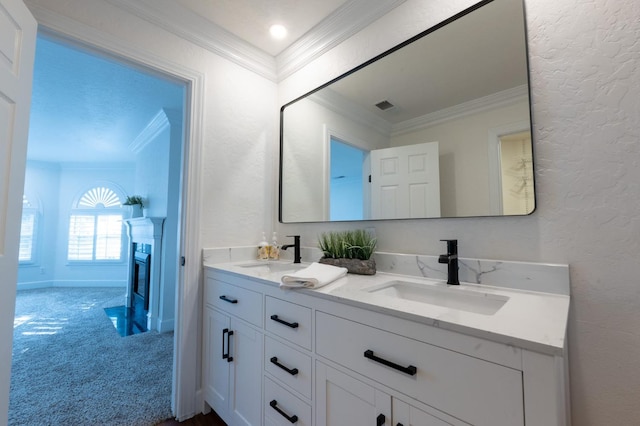 bathroom with a fireplace, ornamental molding, and vanity